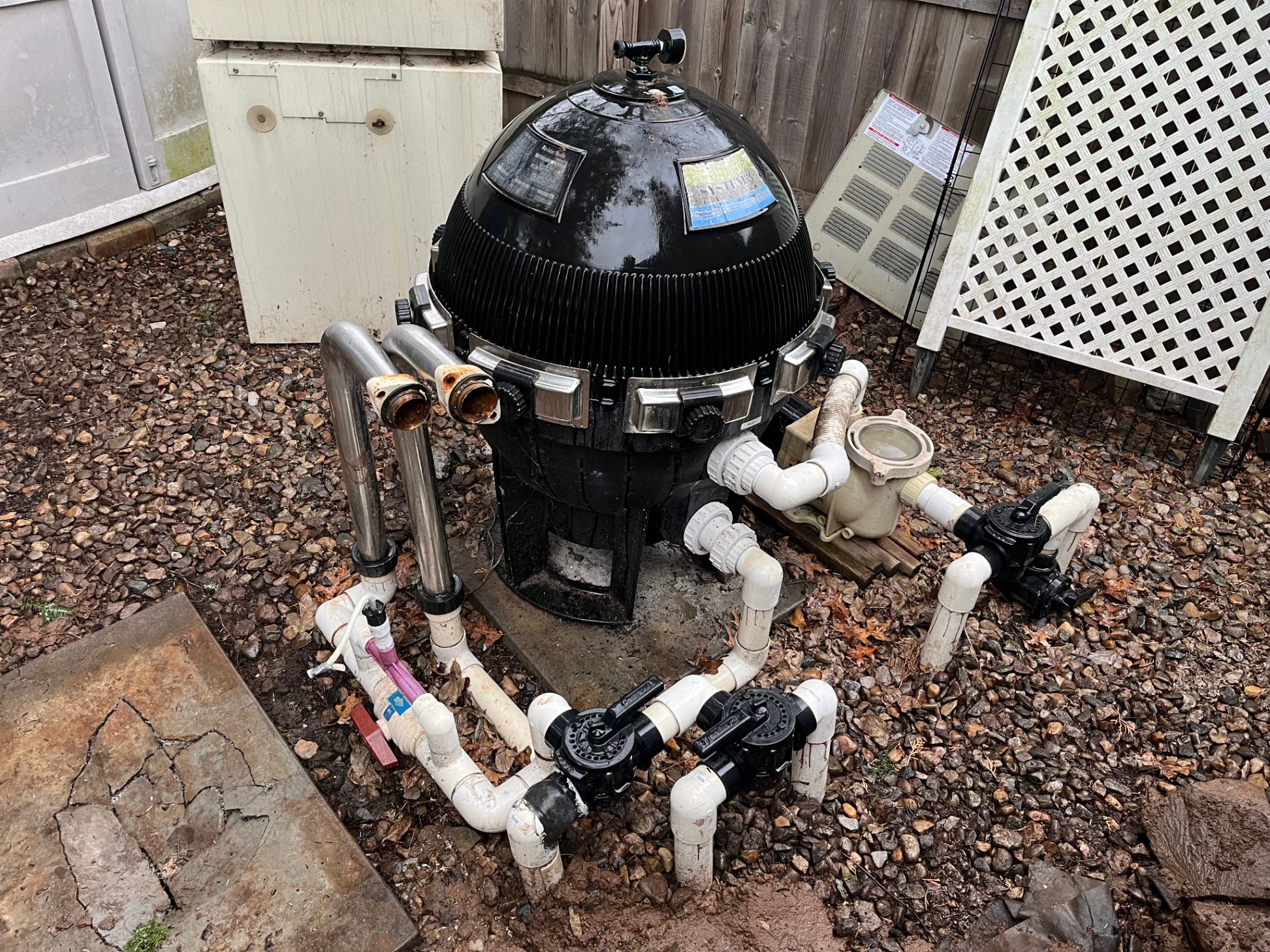 Old failing pool filter and pump setup before equipment replacement
